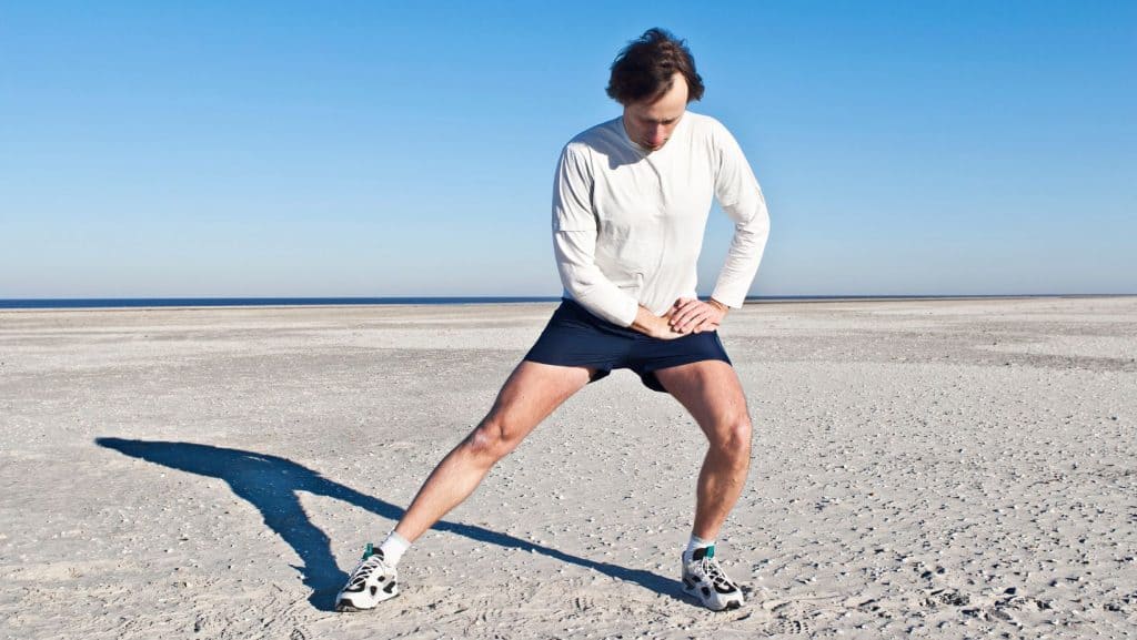 Photo of man doing an adductor stretch